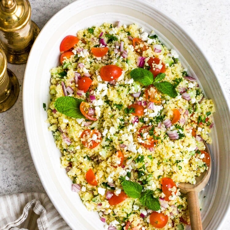 closeup of couscous salad in a white bowl.