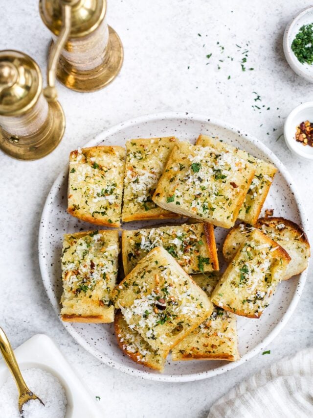 overhead view of garlic bread on a white plate