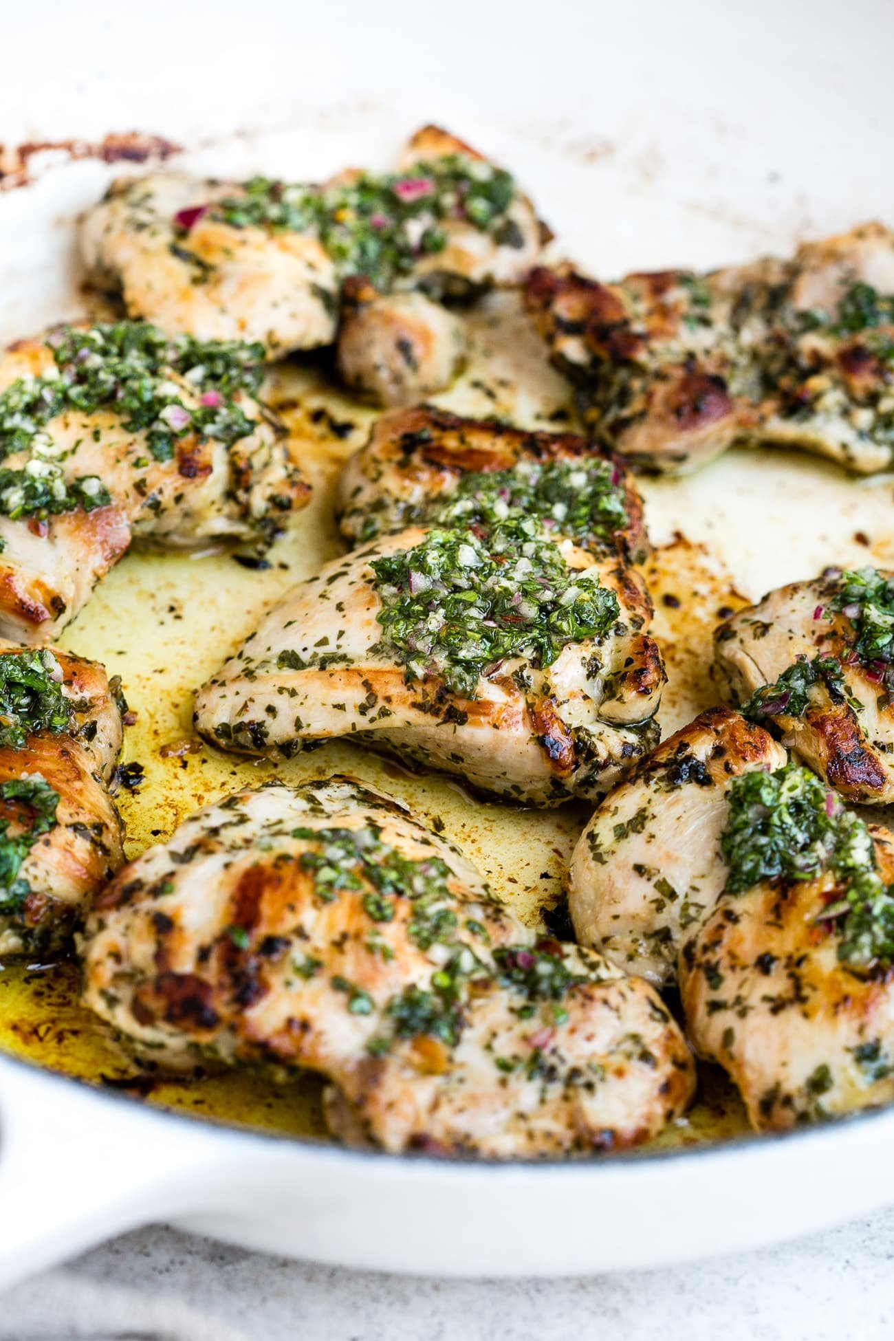 Chimichurri chicken in a large, white skillet.