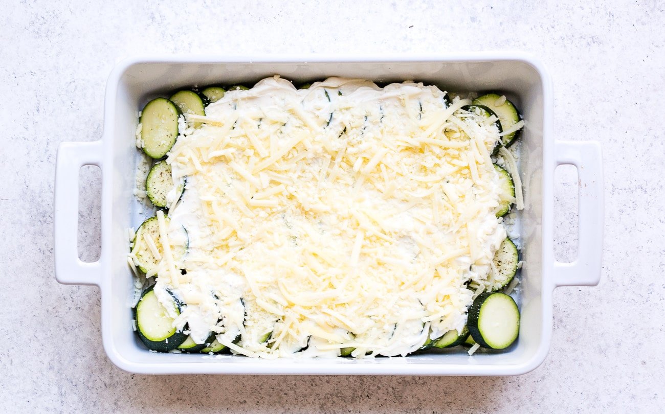 Zucchini slices slathered in cream cheese sauce mixture and sprinkled with mozzarella cheese.