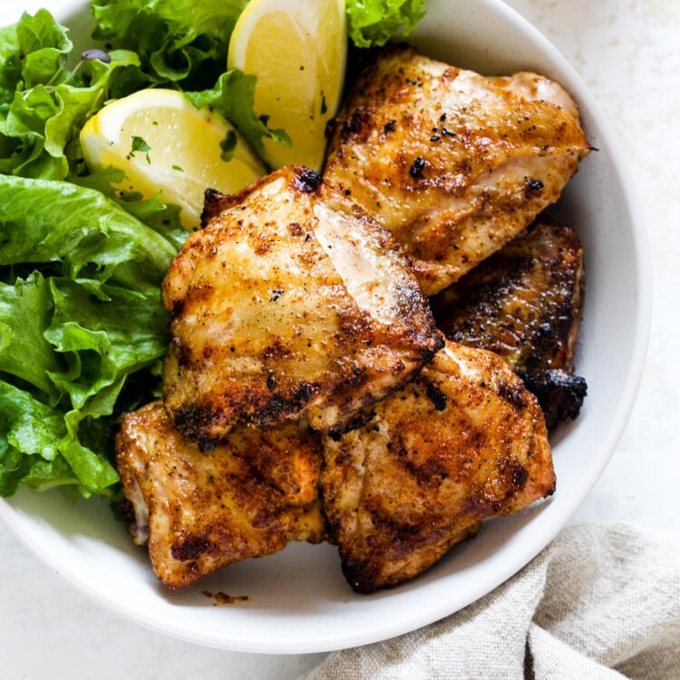 overhead view of Grilled Chicken Thighs in a white bowl
