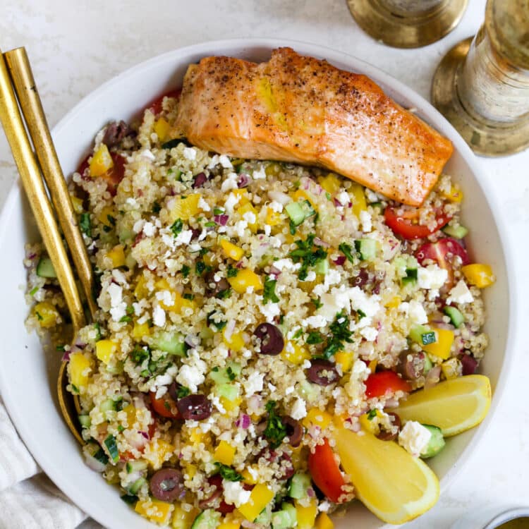 Mediterranean quinoa salad with salmon in a serving bowl.