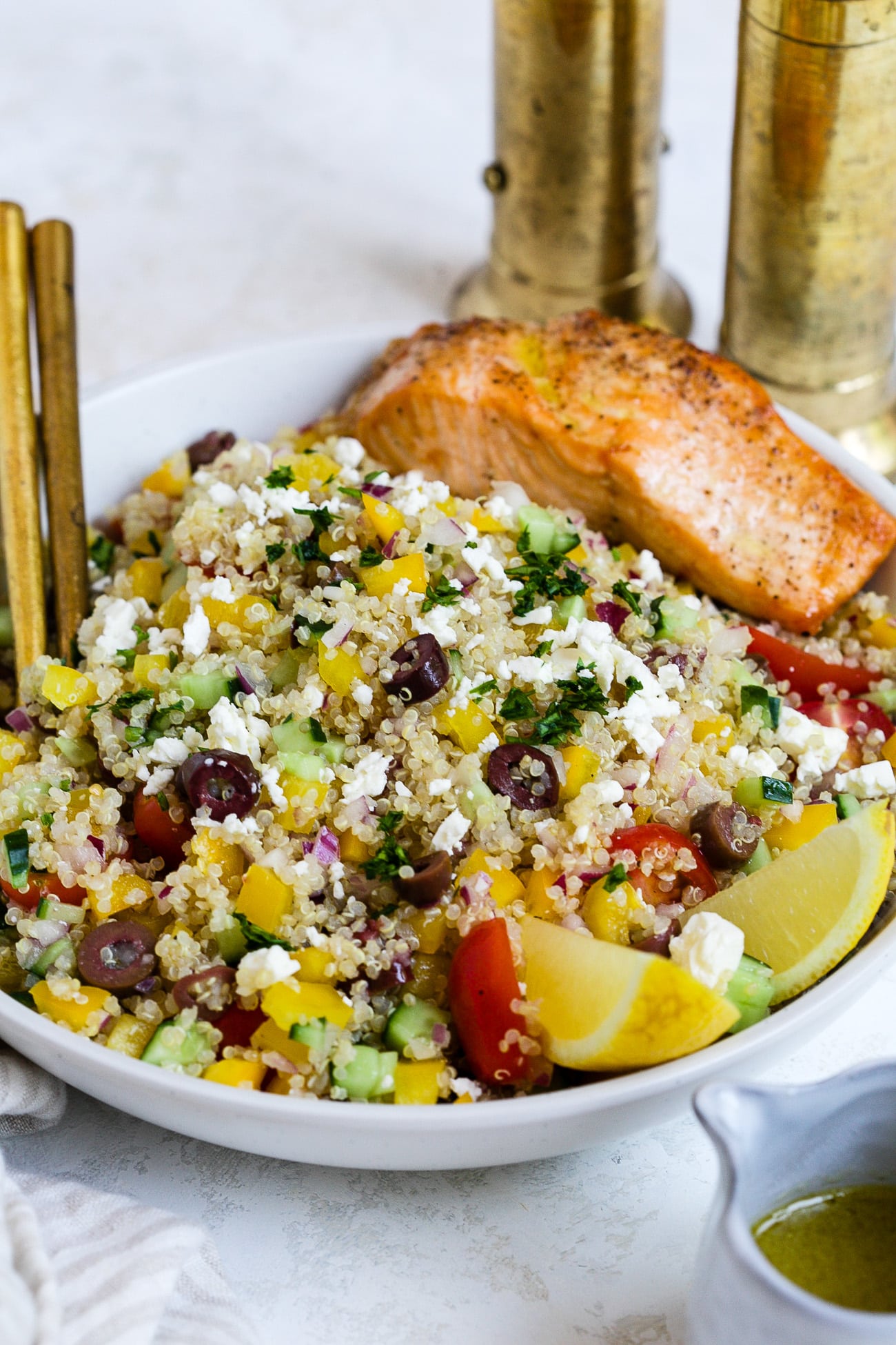 Mediterranean quinoa salad with salmon in a serving bowl. 