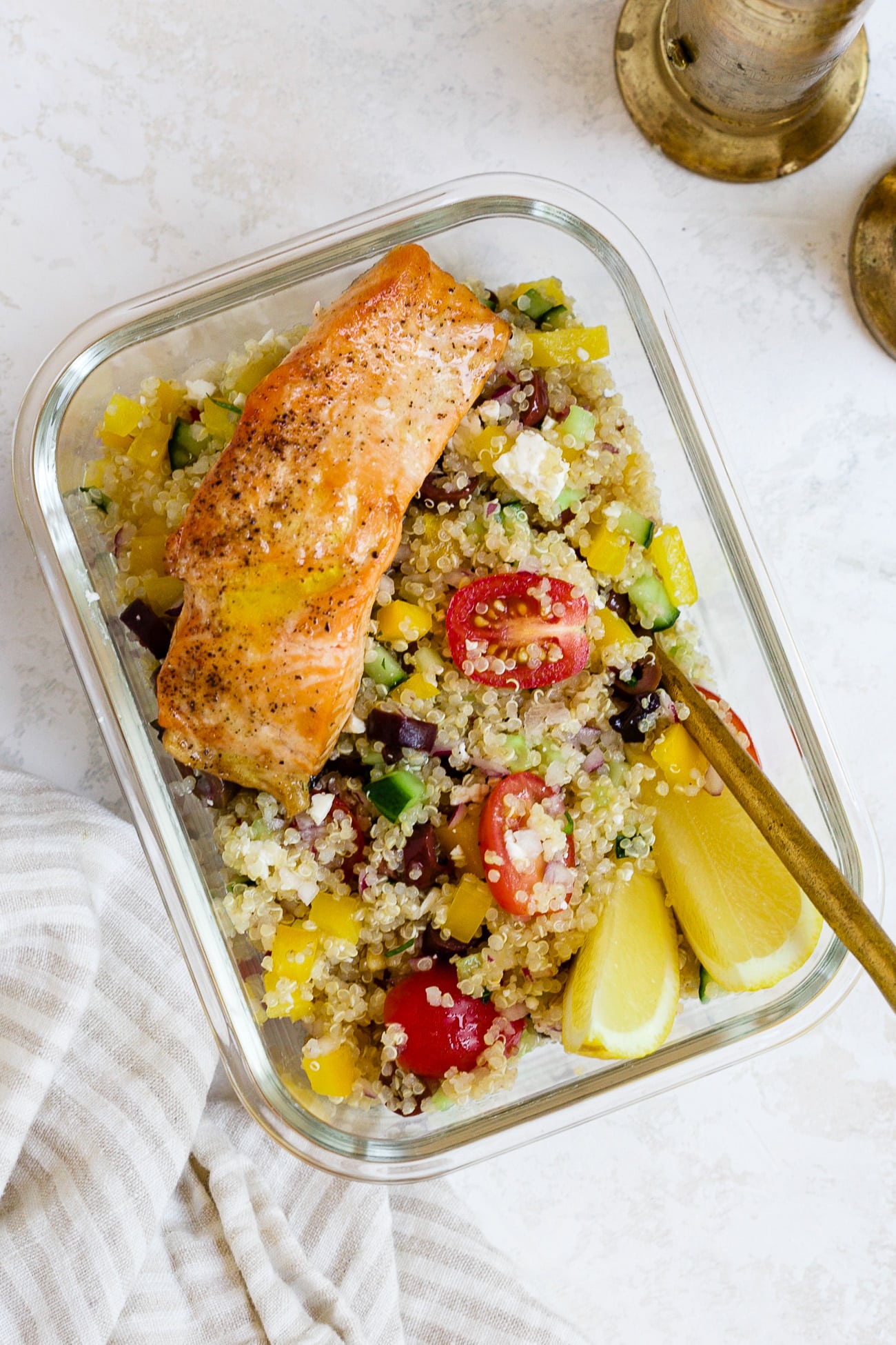 Mediterranean quinoa salad with salmon in a meal-prep container.