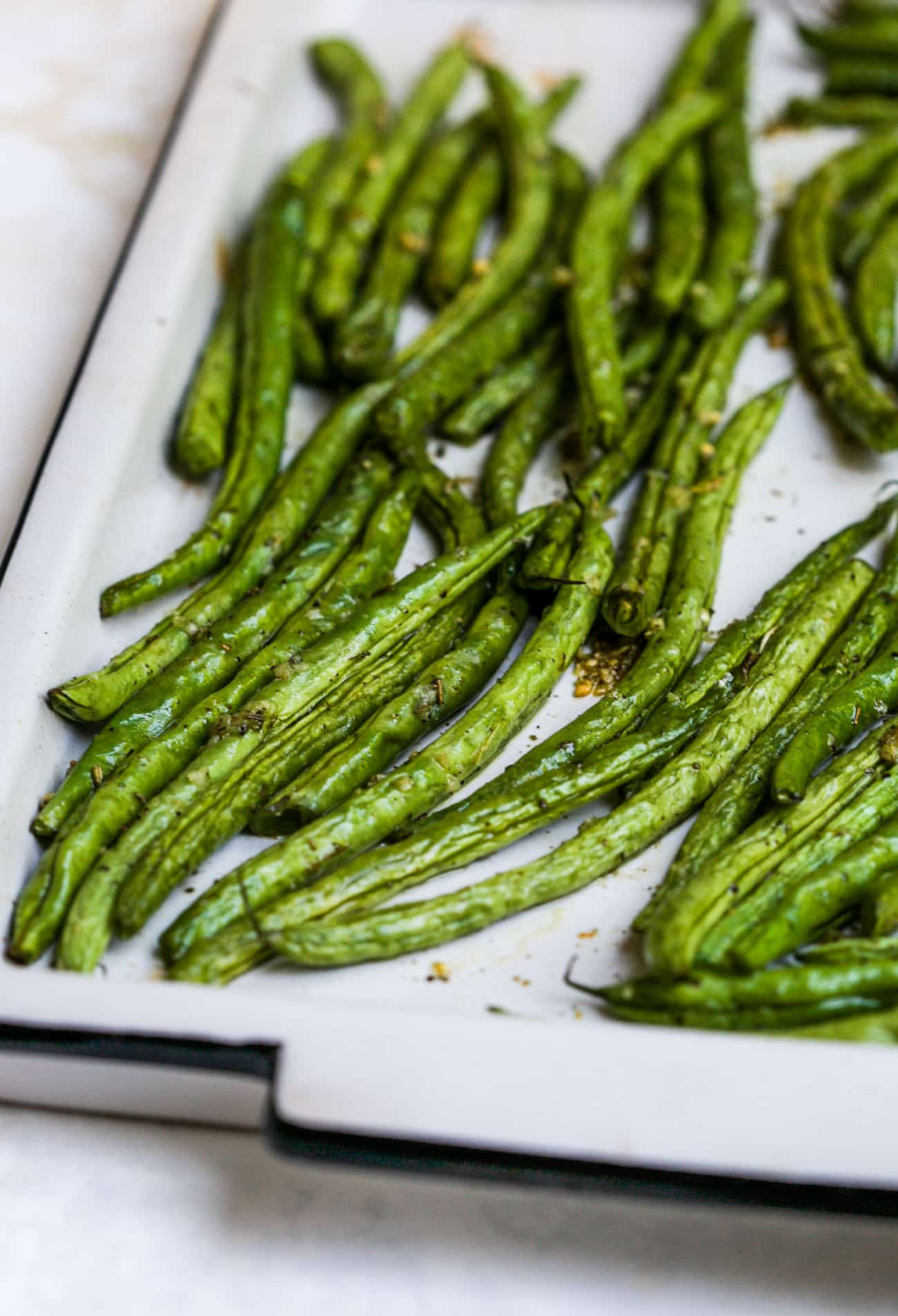 Roasted green beans on a large baking sheet.