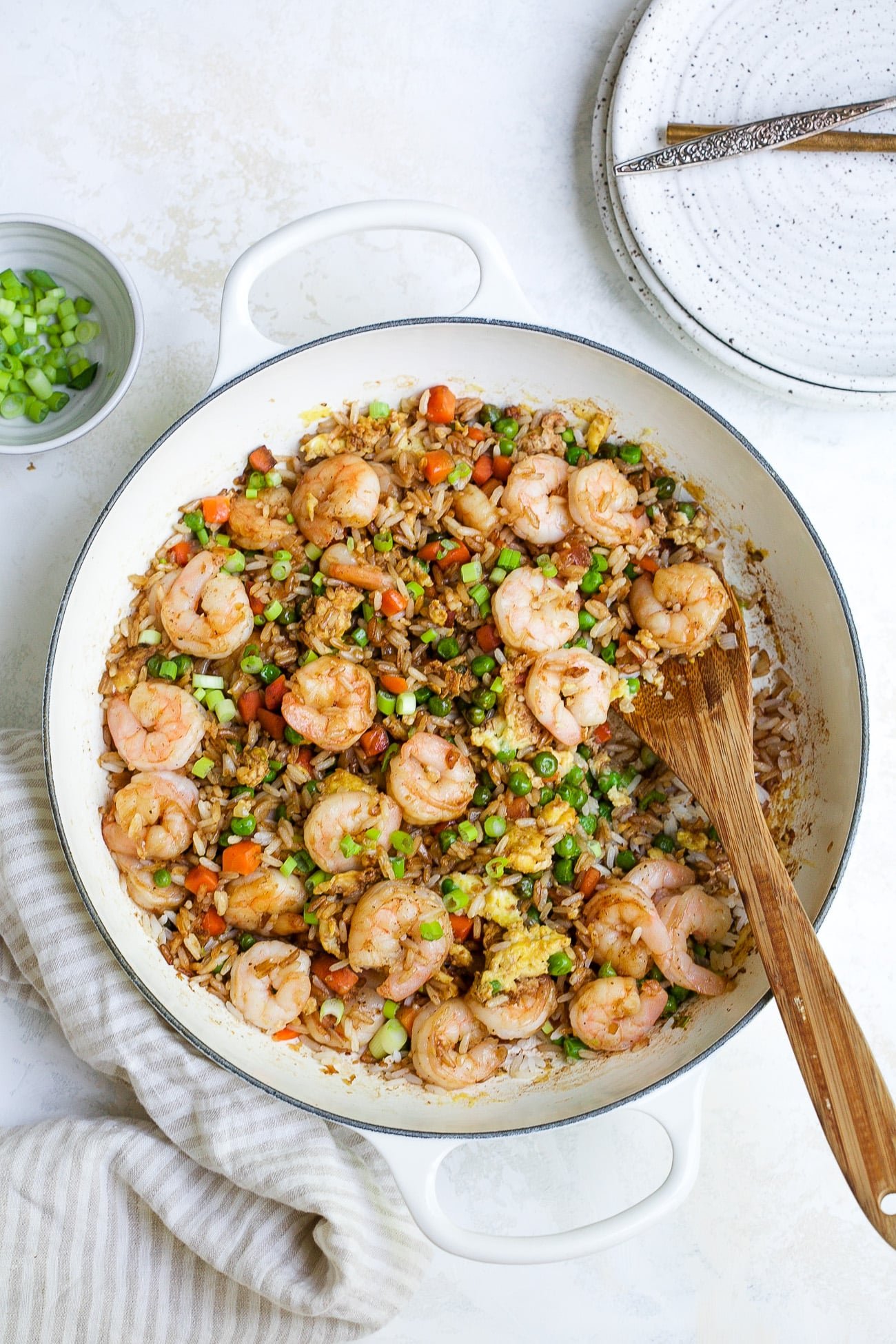 overhead view of shrimp fried rice in a white skillet. 