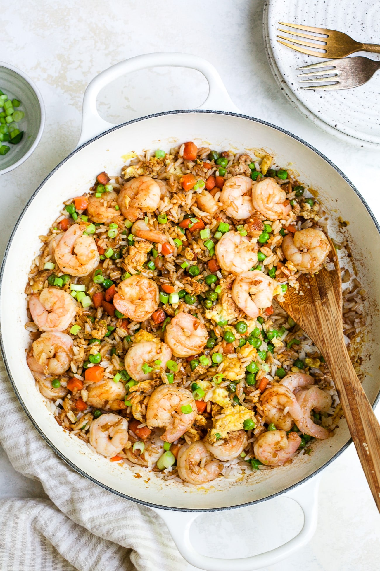 overhead view of shrimp fried rice in a white skillet. 