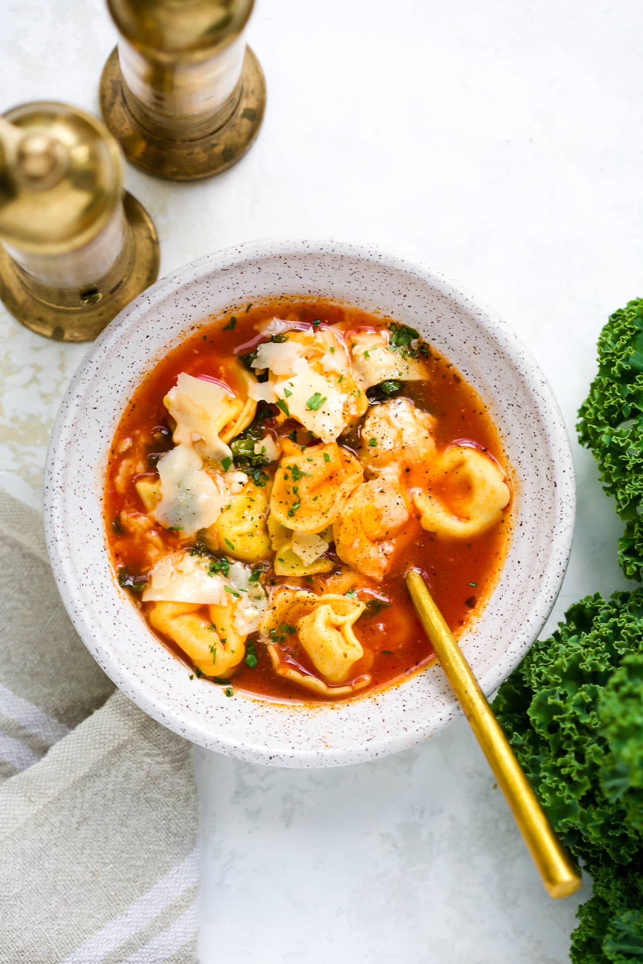 A bowl of kale tortellini soup.