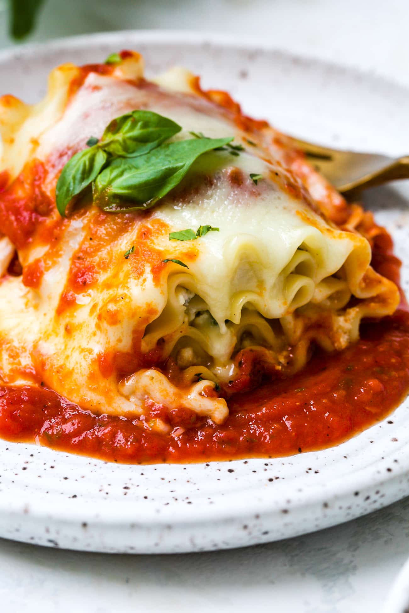 Close up of a plated lasagna roll up.