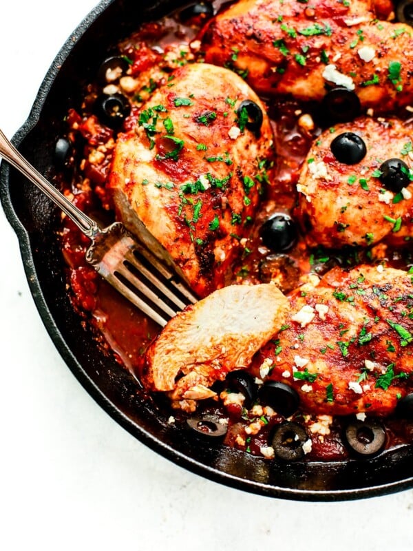 overhead view of a cast iron skillet containing Mediterranean Chicken breast