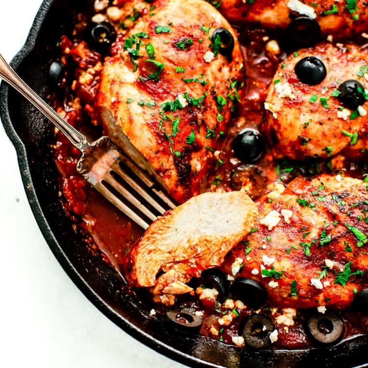 overhead view of a cast iron skillet containing Mediterranean Chicken breast