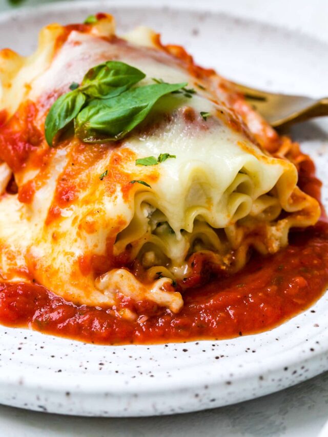 closeup of a lasagna roll ups on a white plate