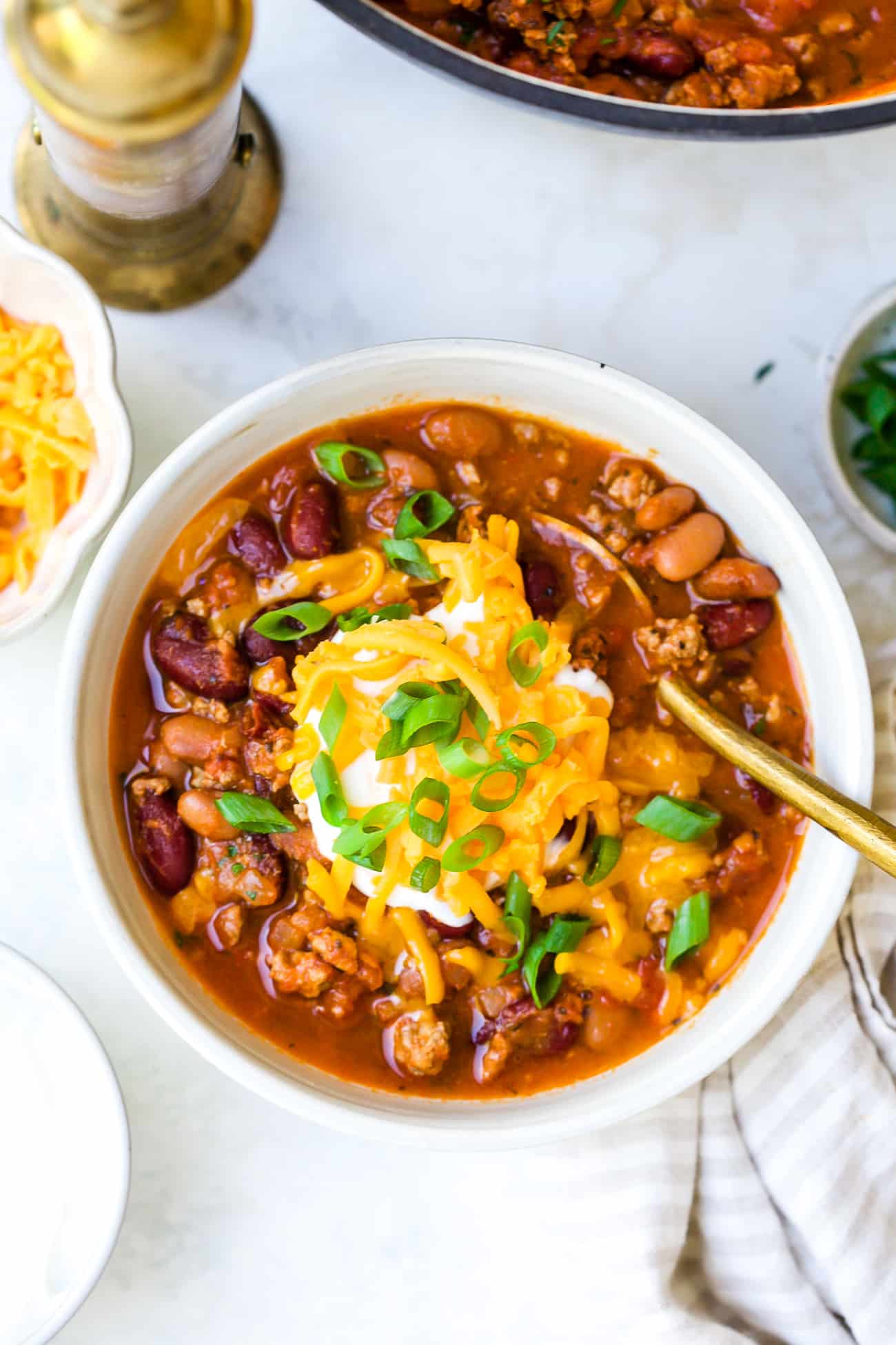 Close up of chili in a bowl with toppings.