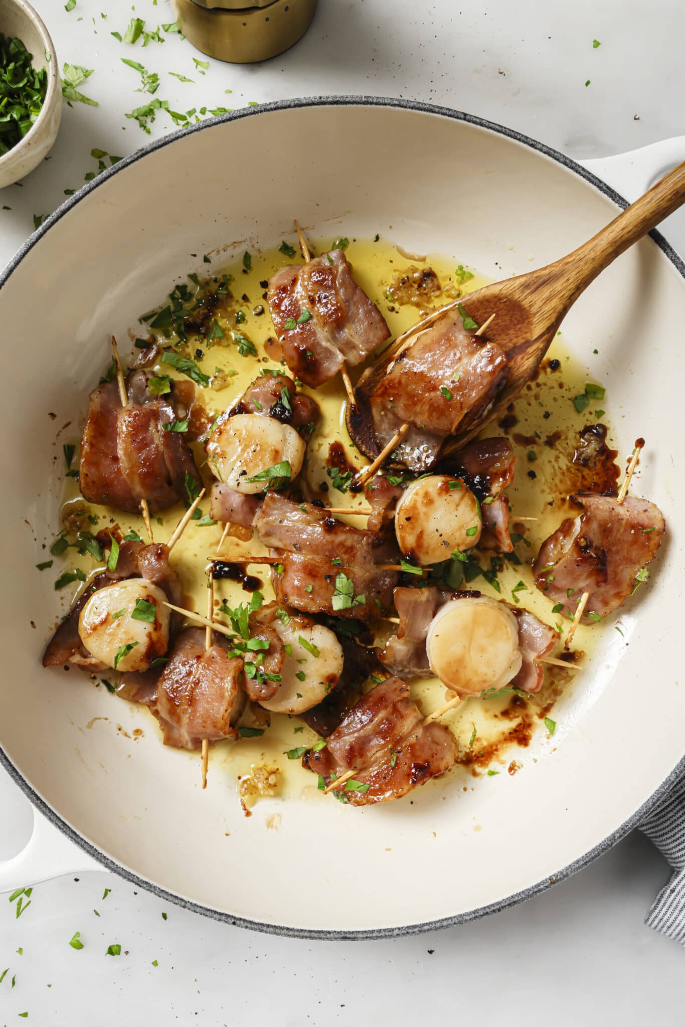 Close up of Bacon Wrapped scallops in a skillet. 