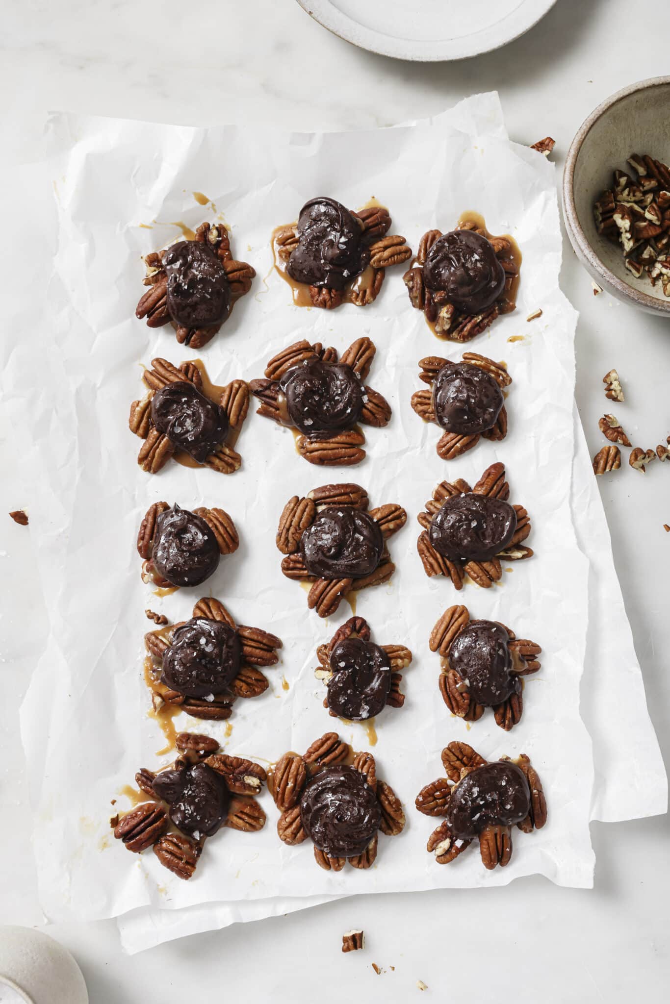 Close up of Chocolate Turtles on parchment paper. 