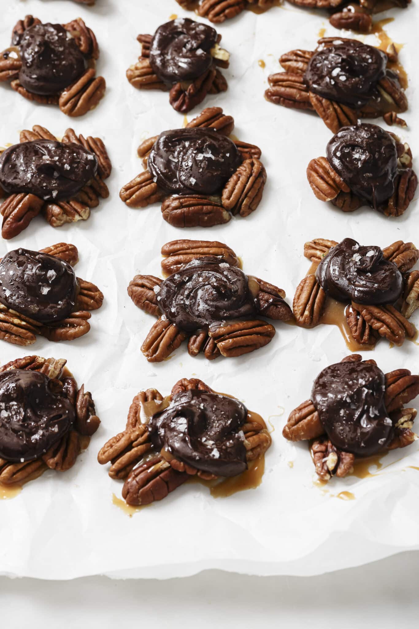 Close up of Chocolate Turtles on parchment paper. 