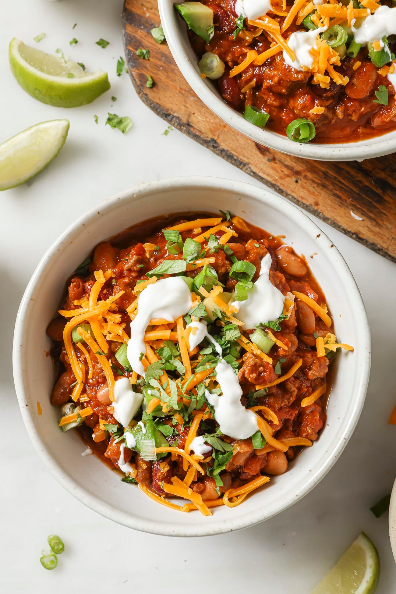 Slow cooker chili in a bowl with toppings. 