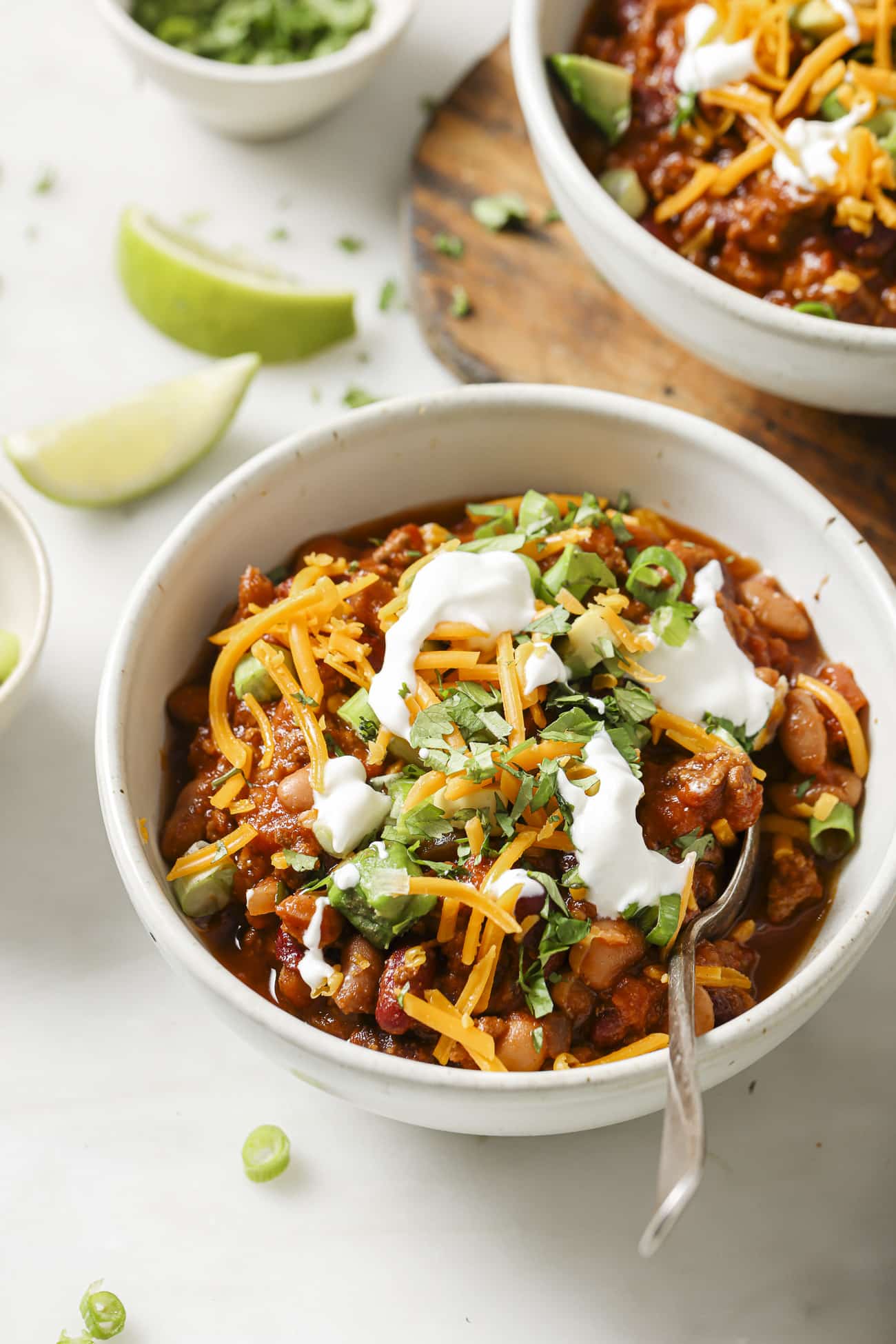 Slow cooker chili in a bowl with toppings. 