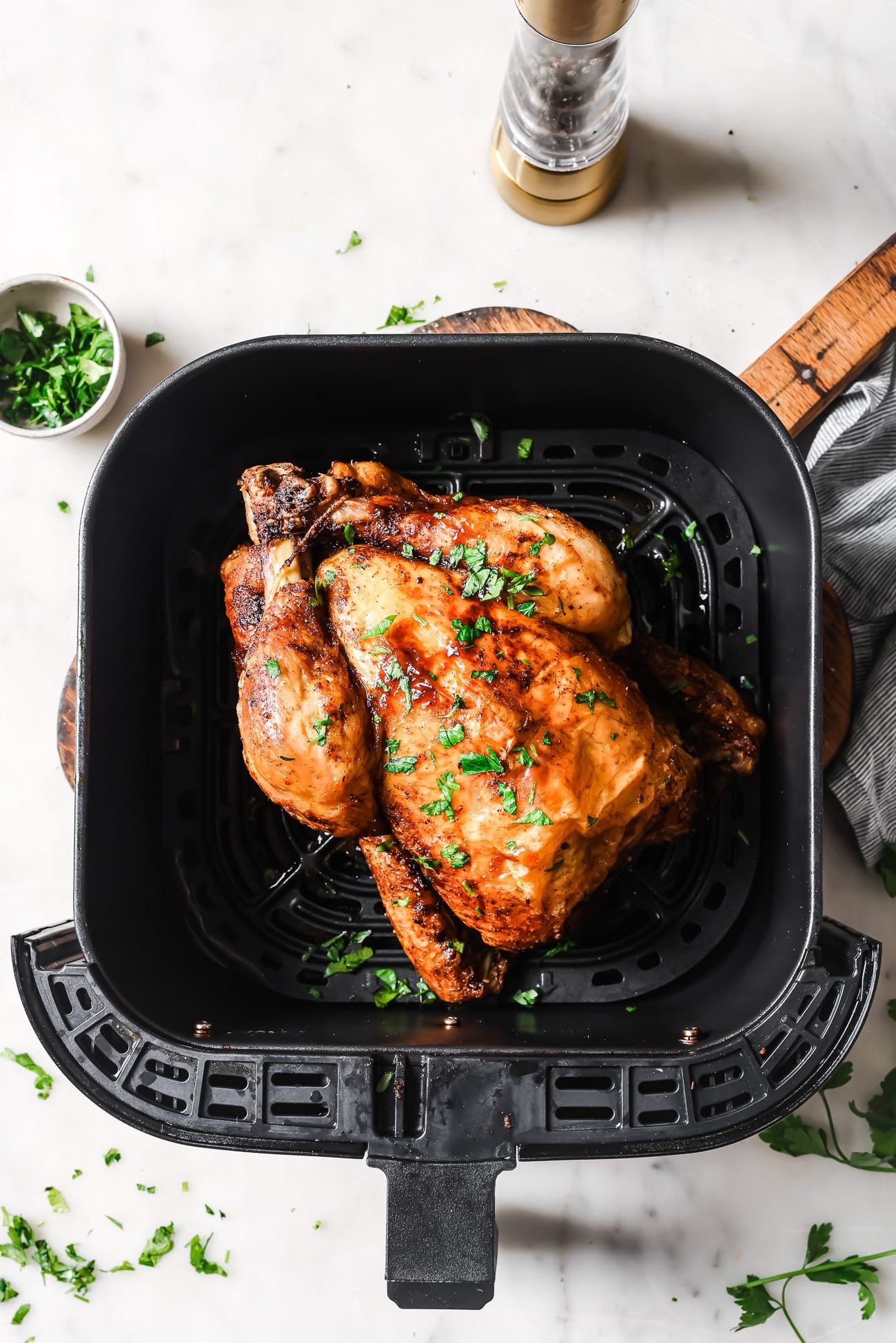 A cooked whole chicken in the air fryer.