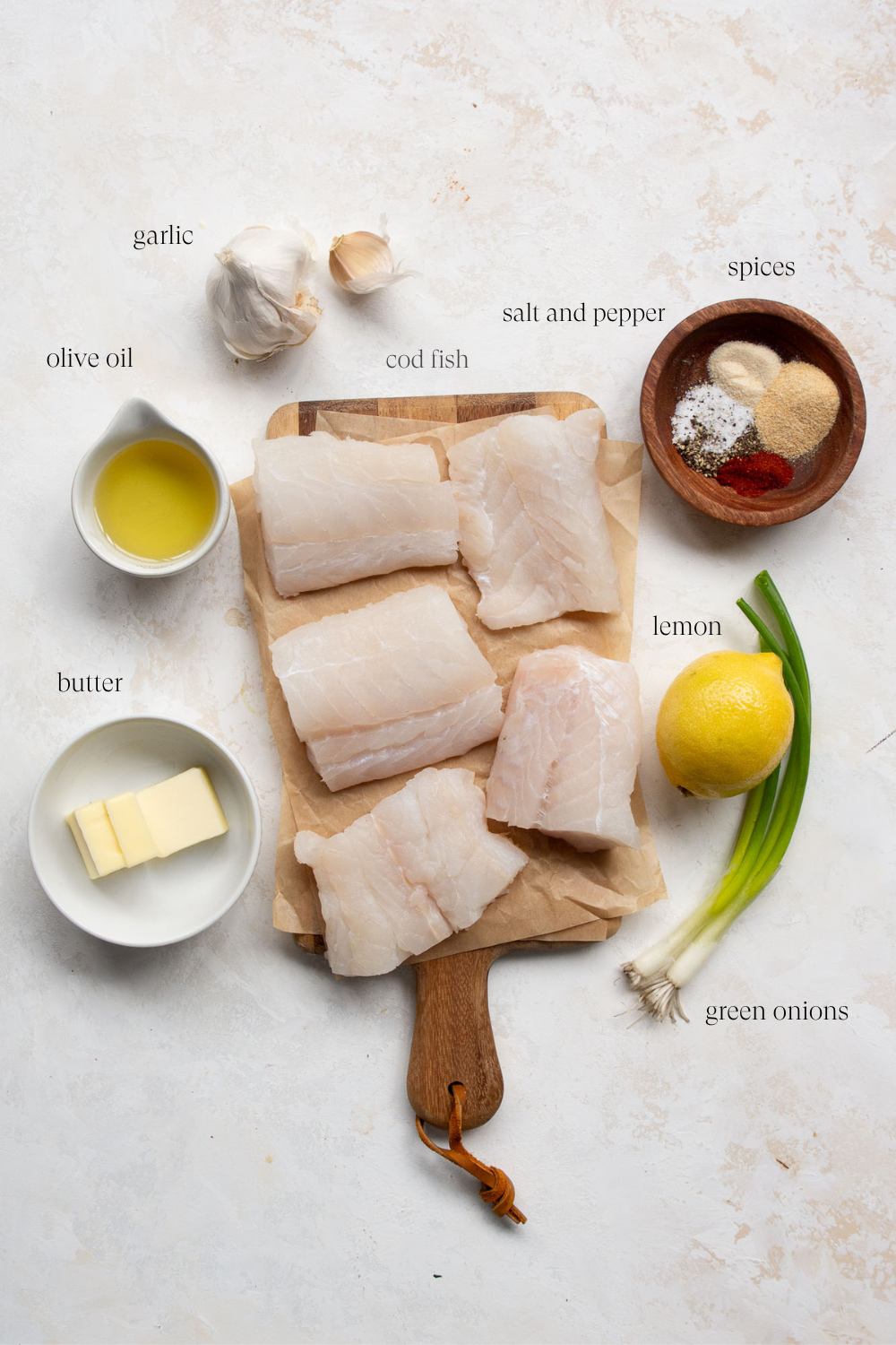 Overhead view of the ingredients on a countertop to make cod recipe. 
