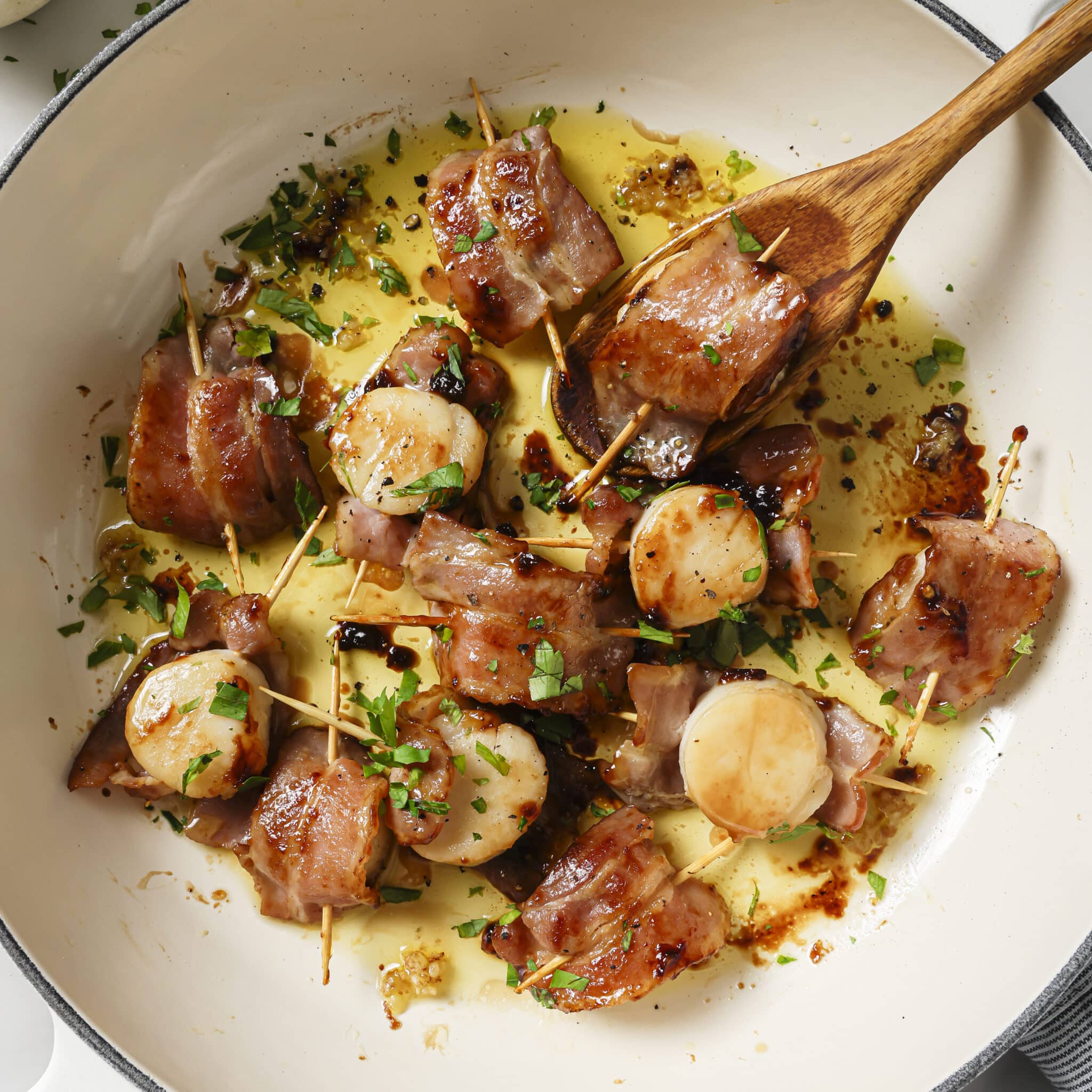 Bacon-Wrapped Scallops in a skillet. 