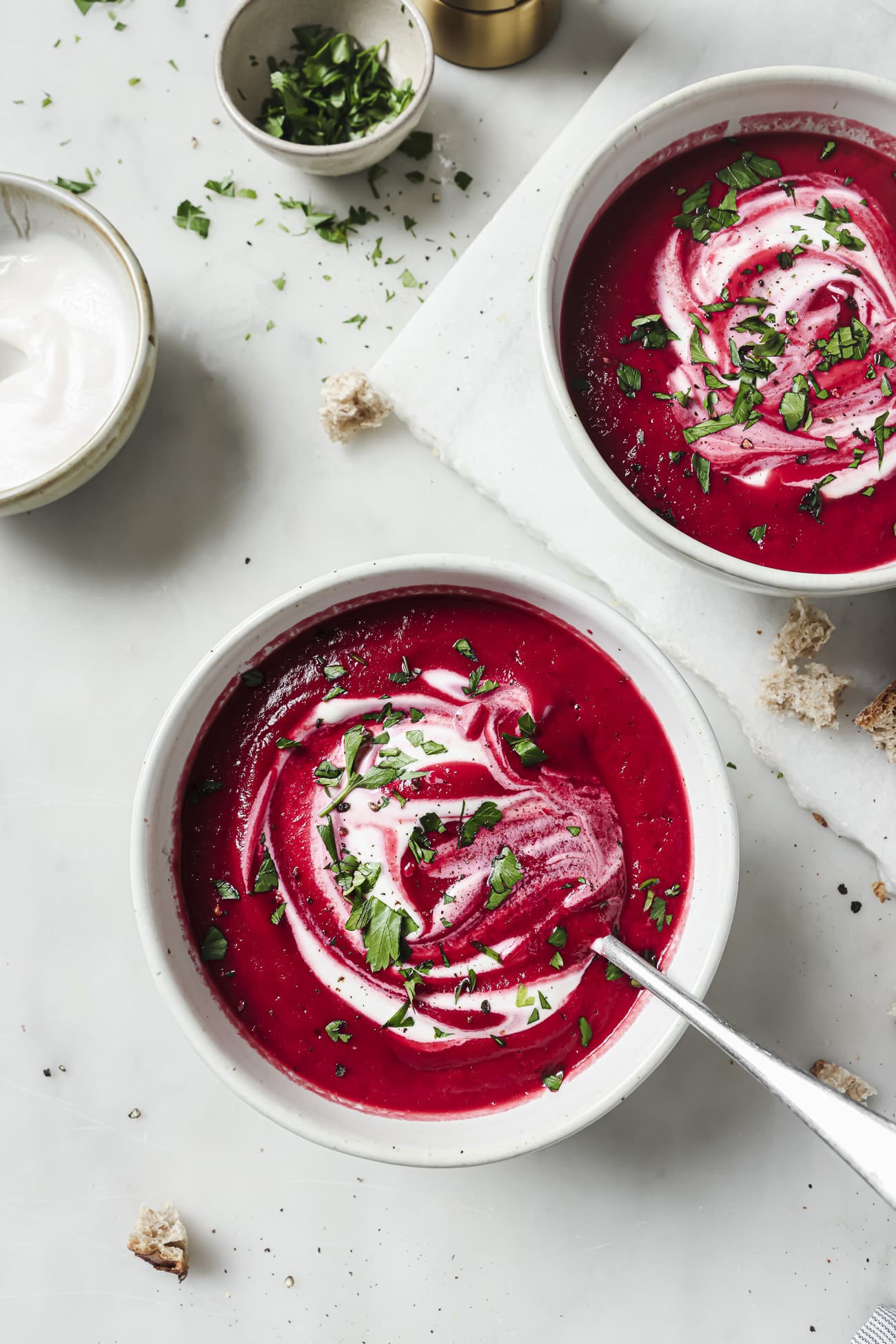 Two bowls of Beet Soup with garnish. 