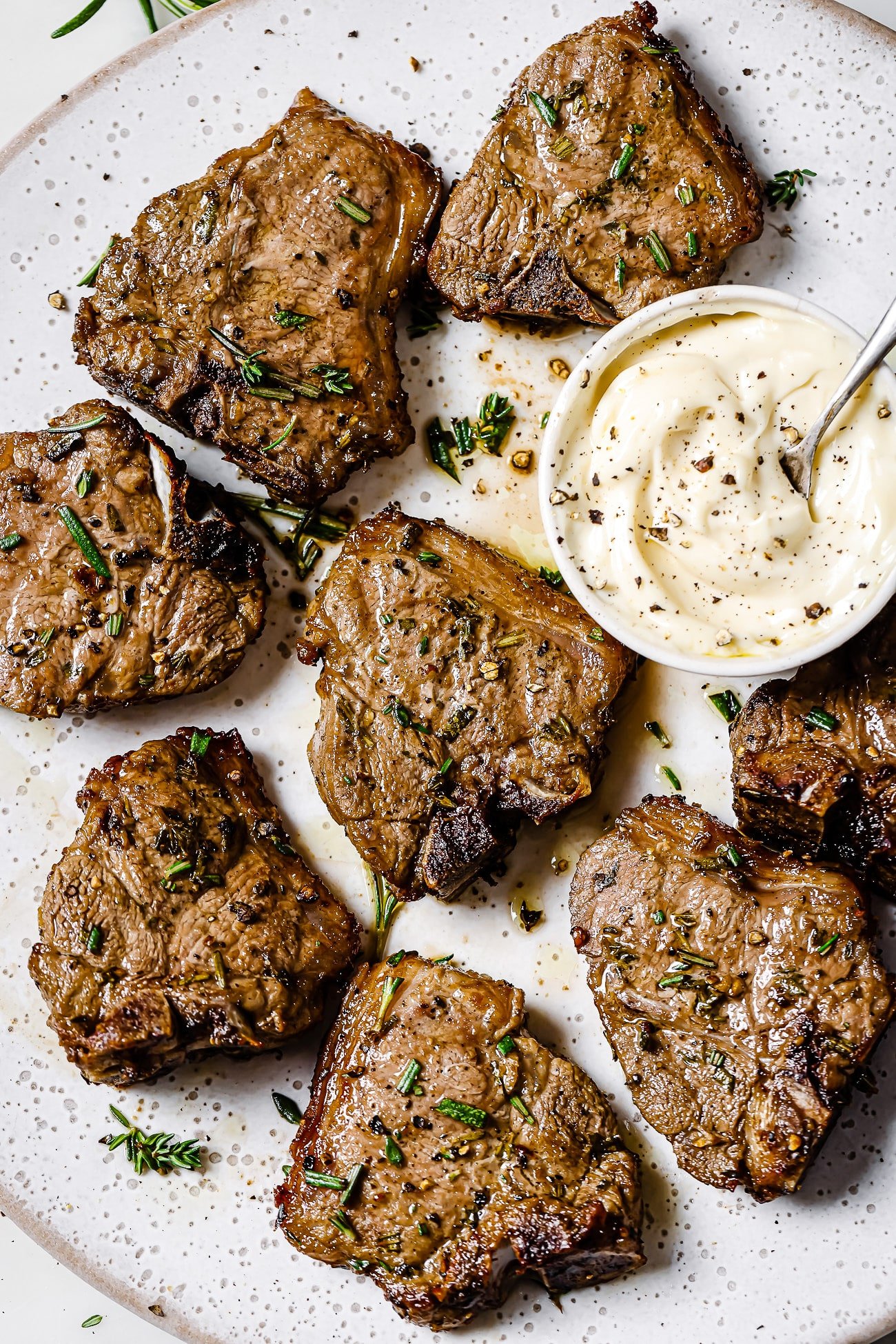 Close up of air fryer lamb chops on a white serving plate. 