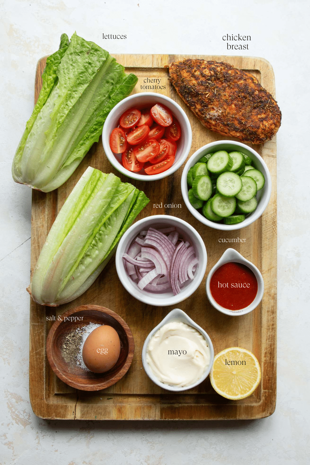 overhead view of ingredients to make a chicken salad in a bowl. 