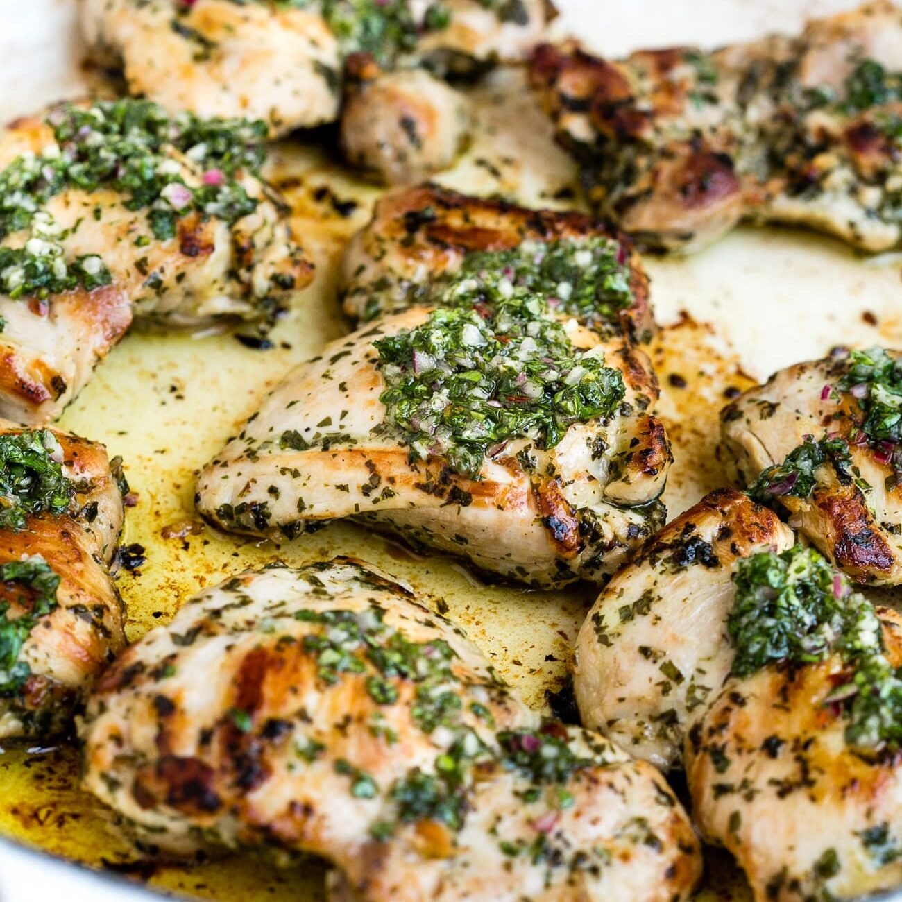 Chimichurri chicken in a large, white skillet.