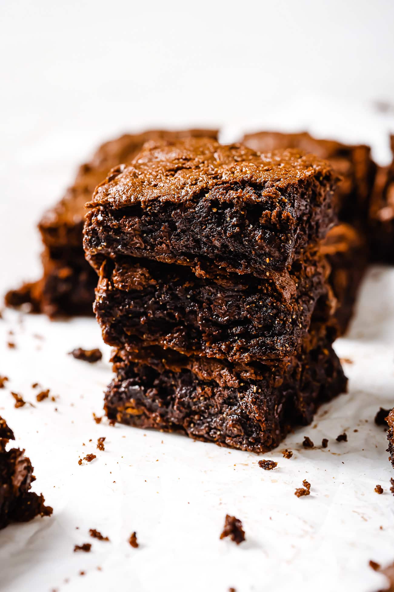 Three square-cut pieces of flourless brownies stacked up. 