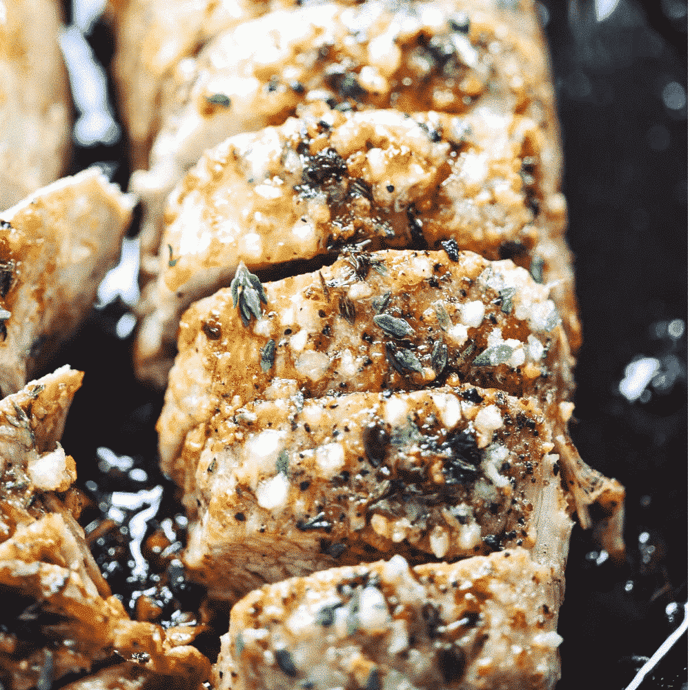 Close up of Garlic Butter Pork Tenderloin in a cast iron skillet. 