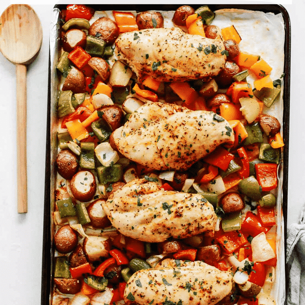 Overhead view of roasted chicken and vegetables on a baking sheet.