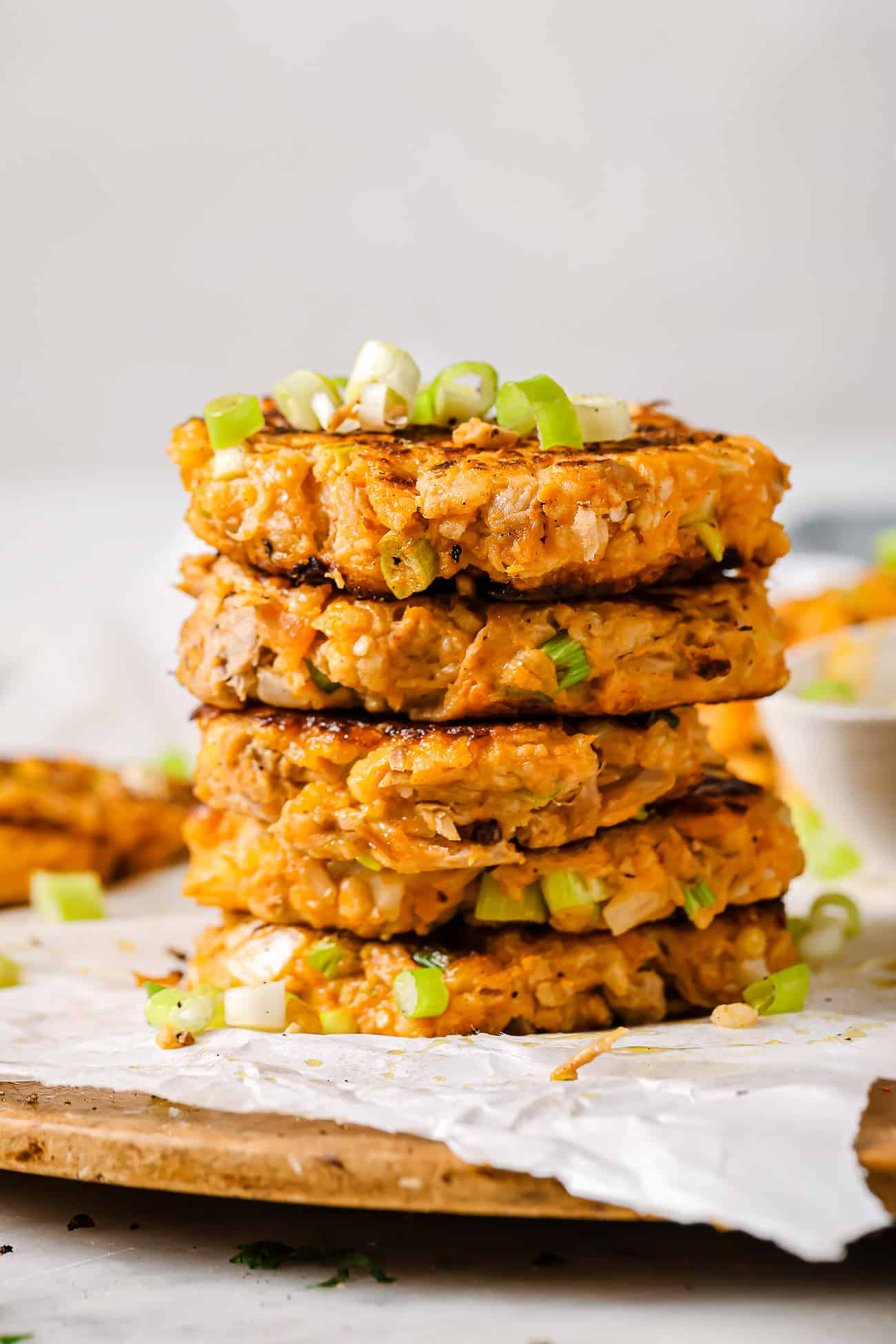 A stack of tuna patties on parchment paper. 