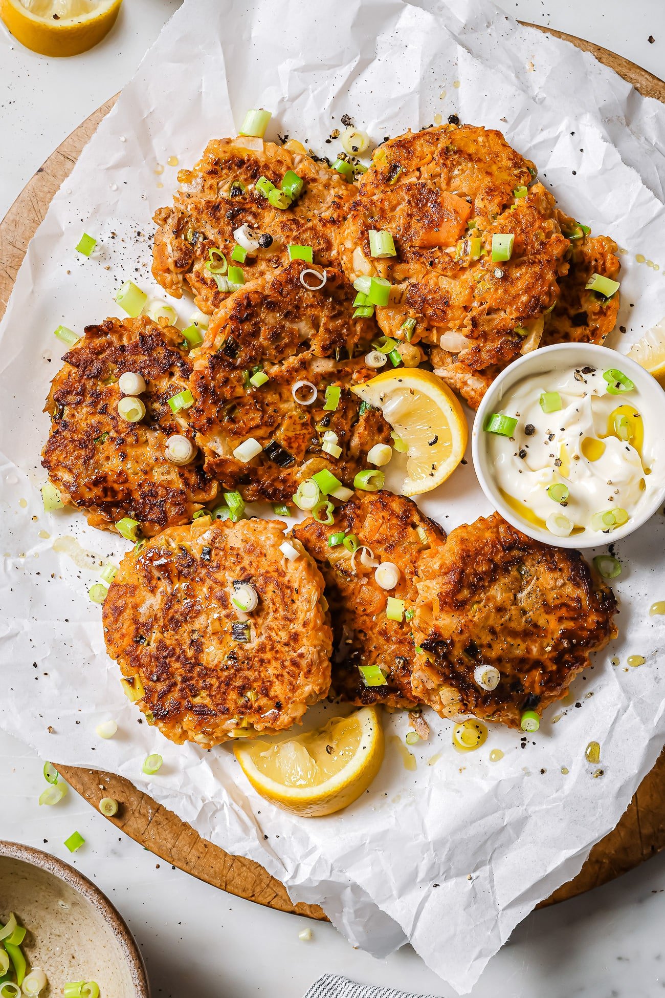 Tuna patties with sweet potato on parchment paper garnished with scallions.