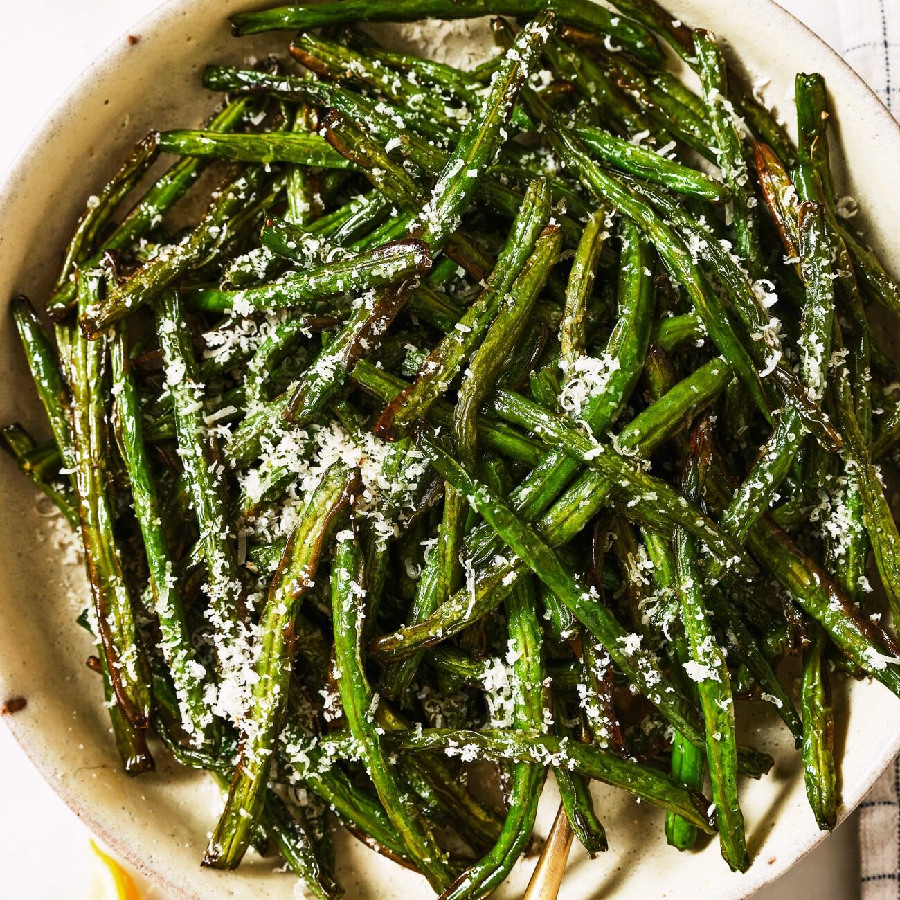 Air fryer green beans in a white serving dish. 