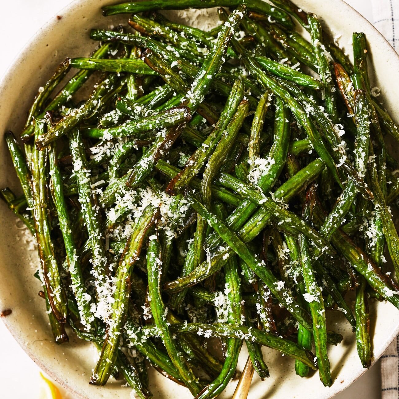 Air fryer green beans in a white serving dish. 