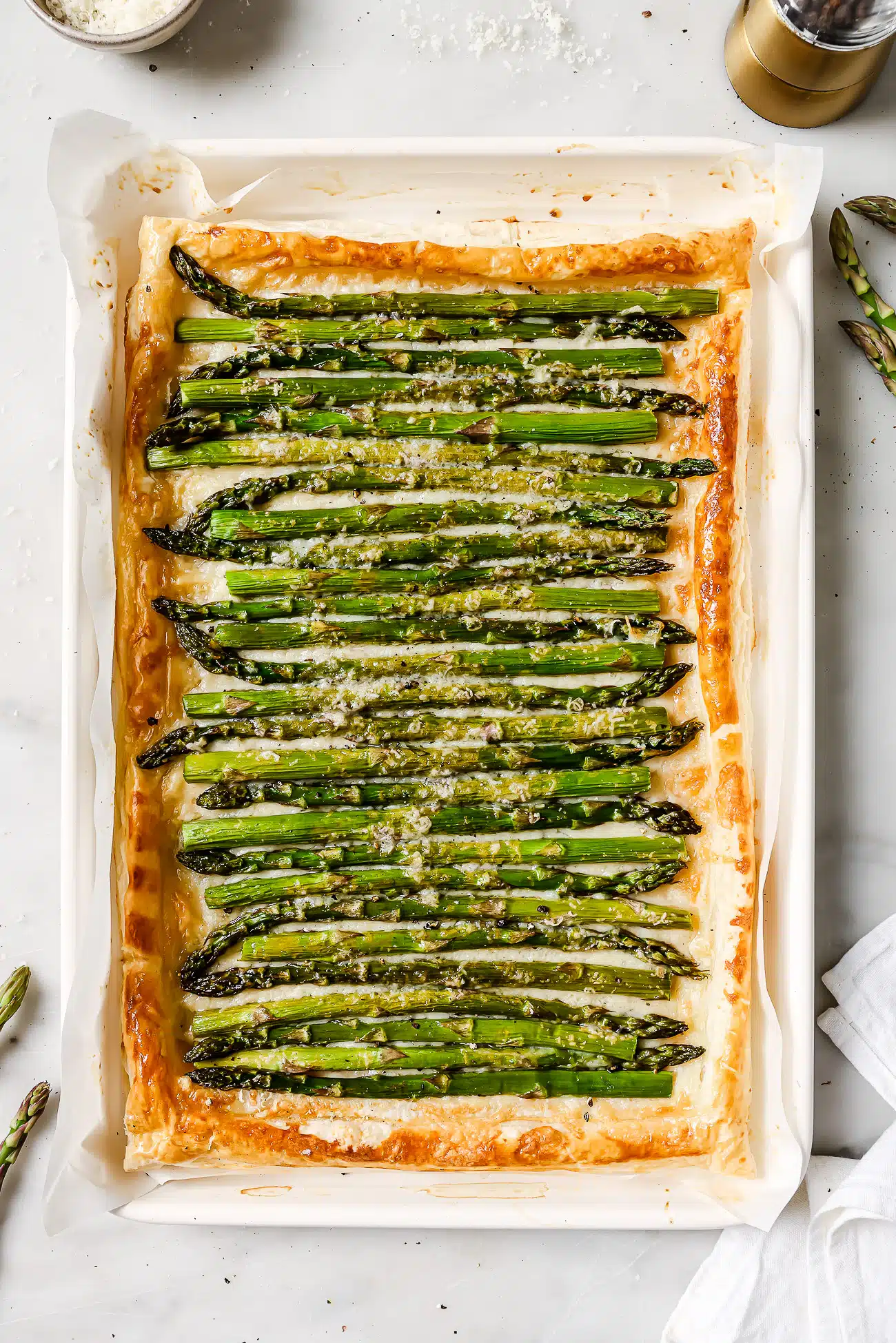 Asparagus tart on a white baking sheet.