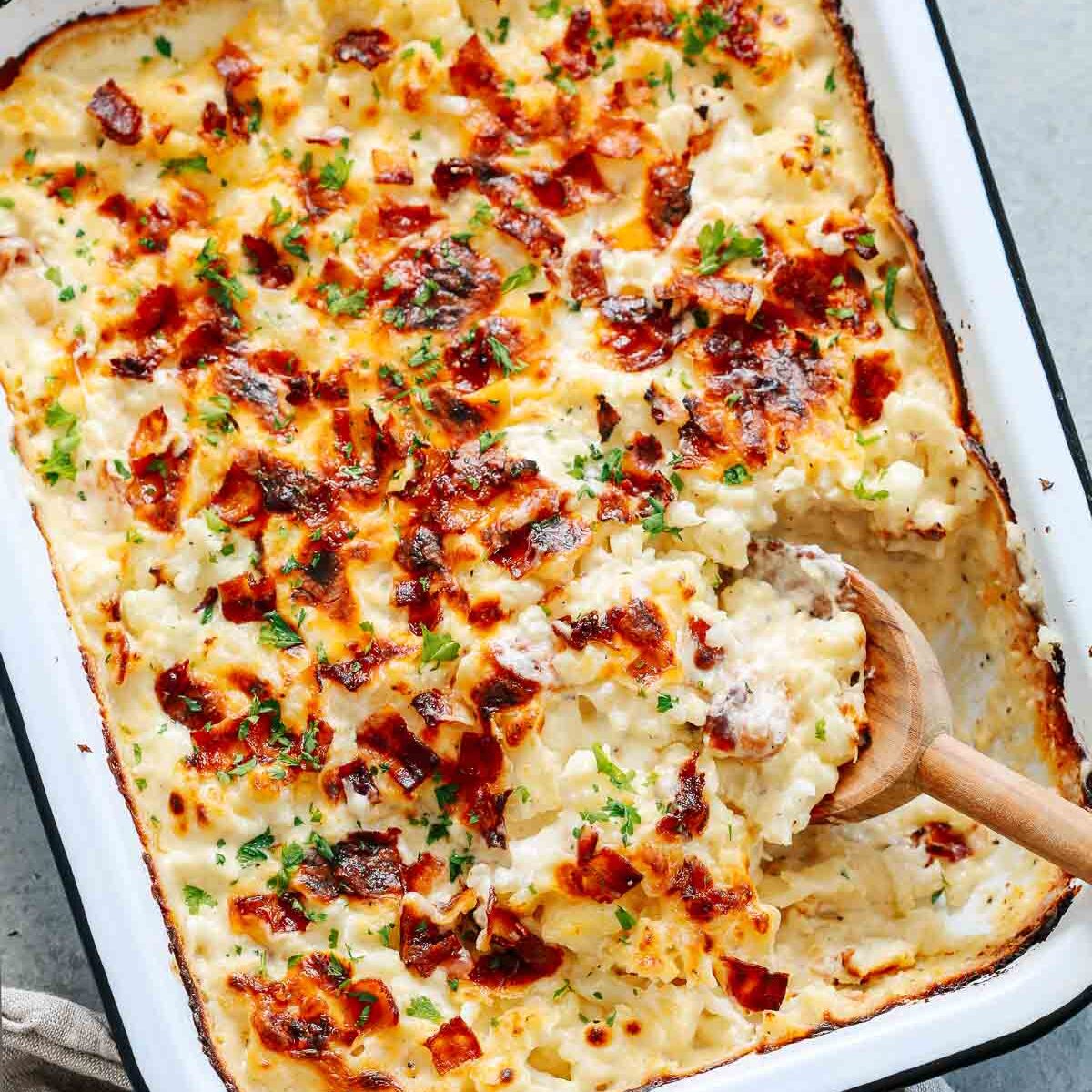 Cauliflower casserole with a spoon dishing out a serving. 