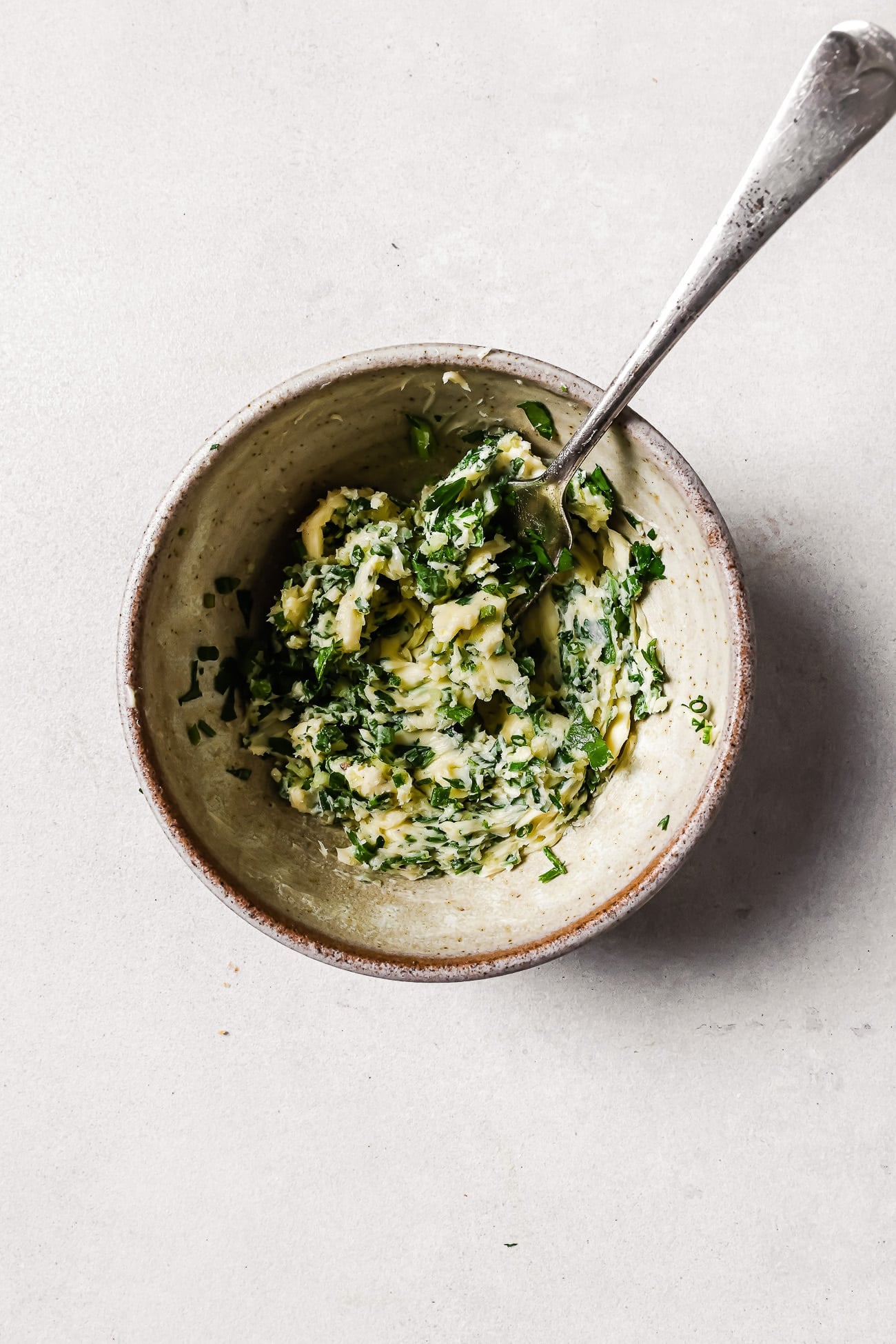 A bowl of compound butter with a spoon in it.
