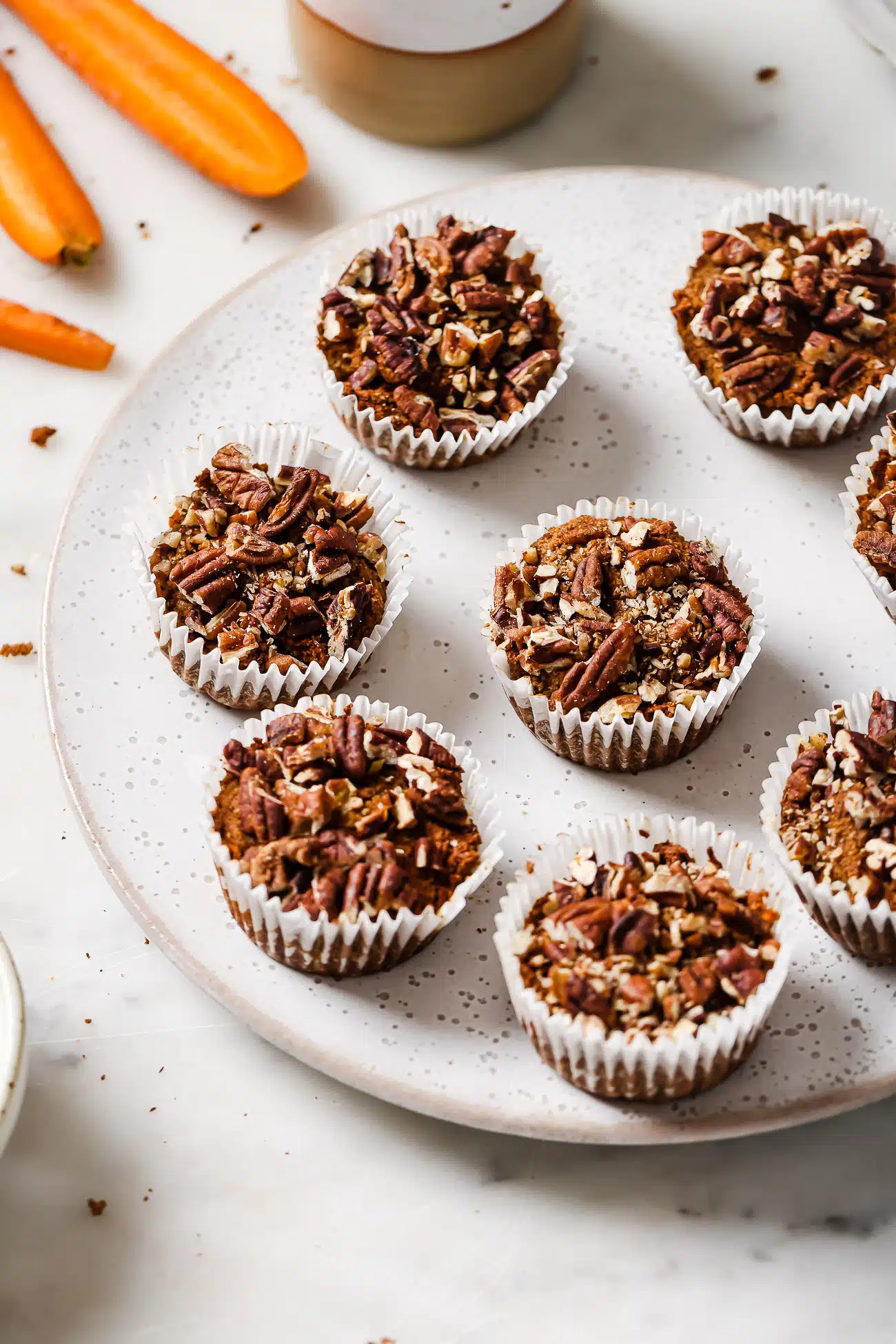 Gluten-free carrot muffins on a white serving dish. 