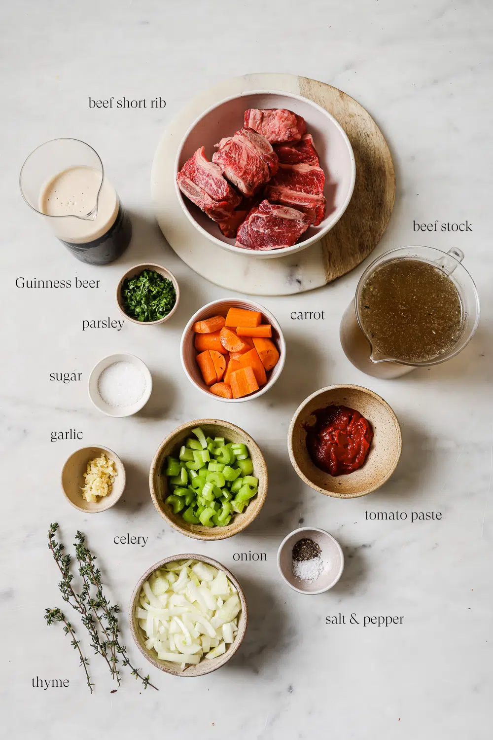 All the ingredients to make the Guinness Short Ribs on a white marble countertop.