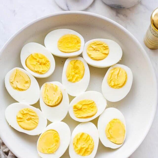 A plate with hard boiled eggs cut in half.
