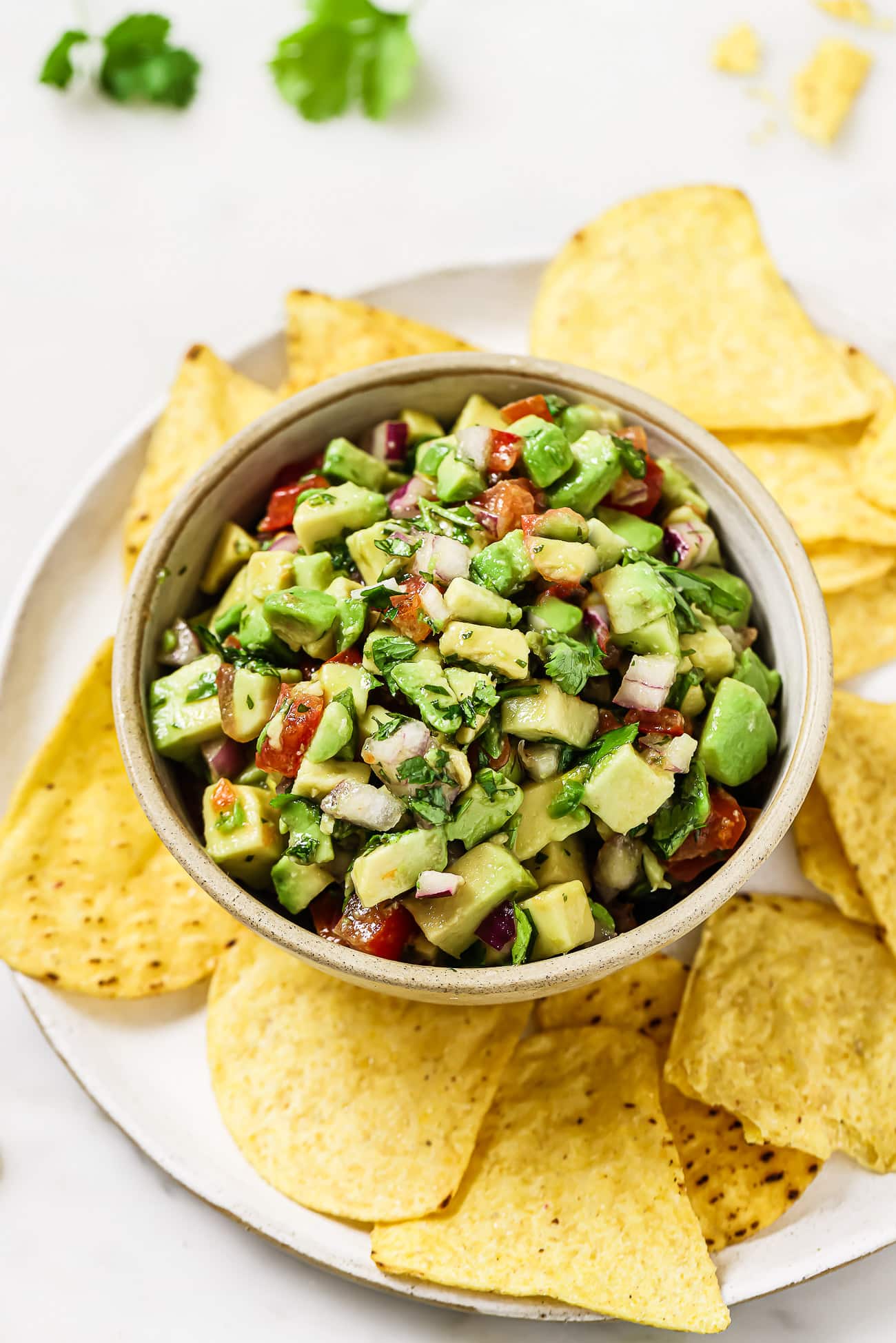 A bowl of avocado salsa with tortilla chips.