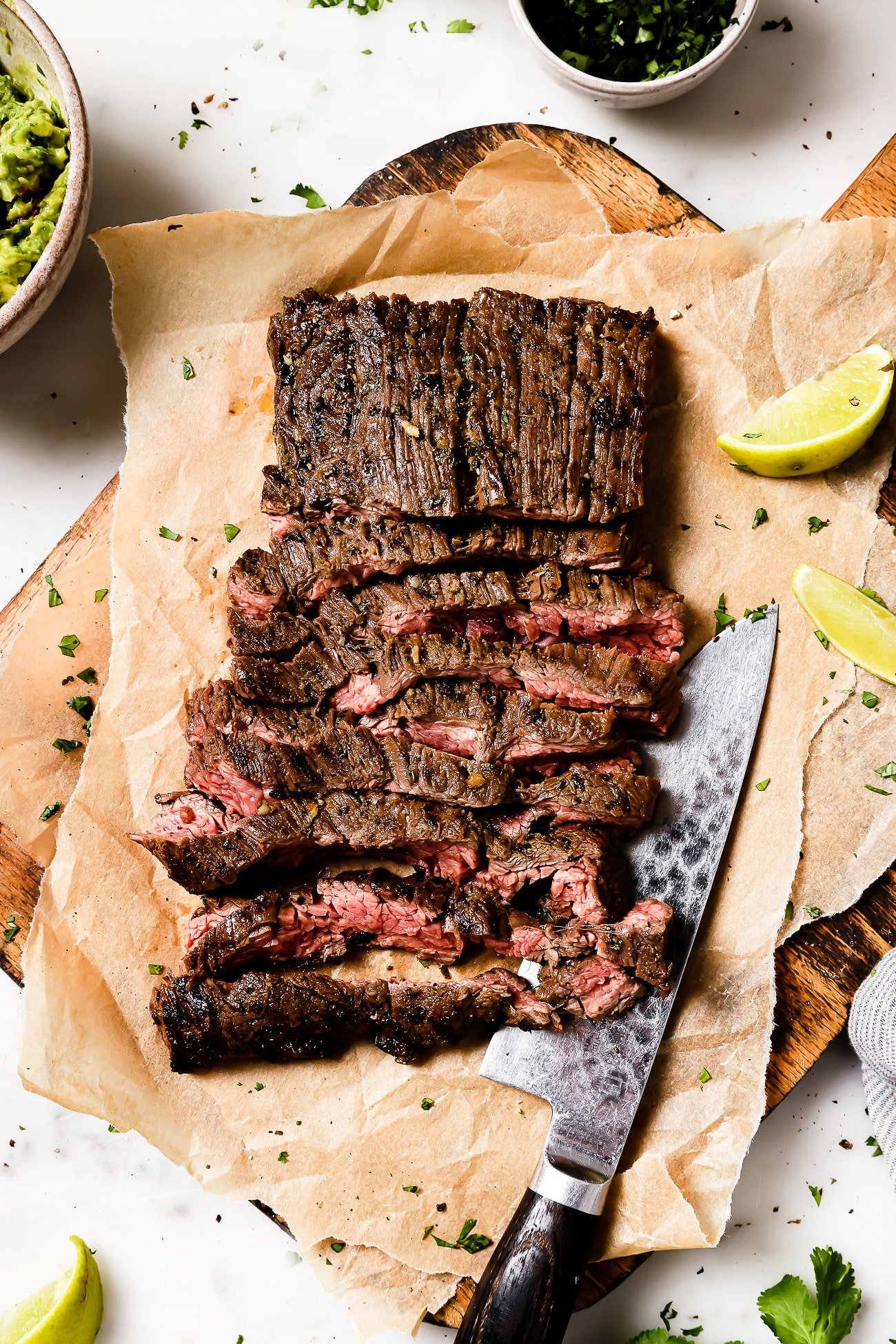 Carne asada cut into slices on parchment paper.