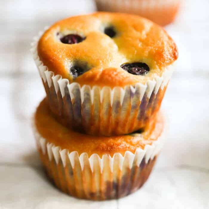 Two blueberry muffins stacked on top of one another.