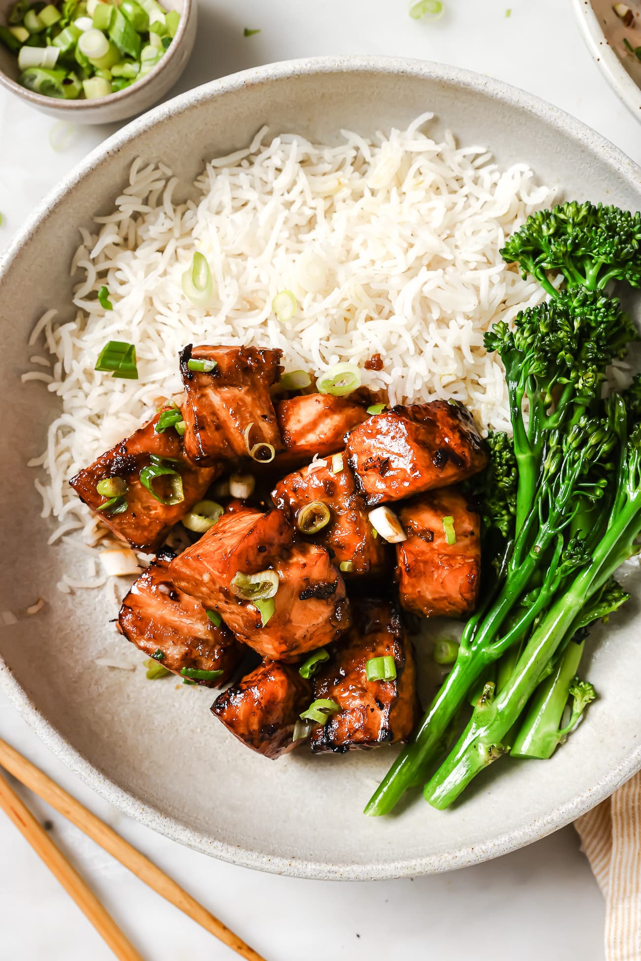 Air fryer salmon bites on a plate with rice and broccoli.