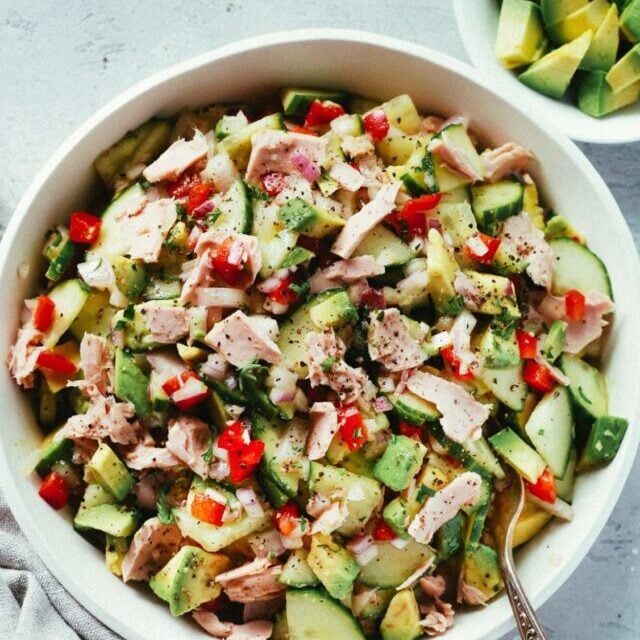 Avocado cucumber tuna salad in a white bowl.