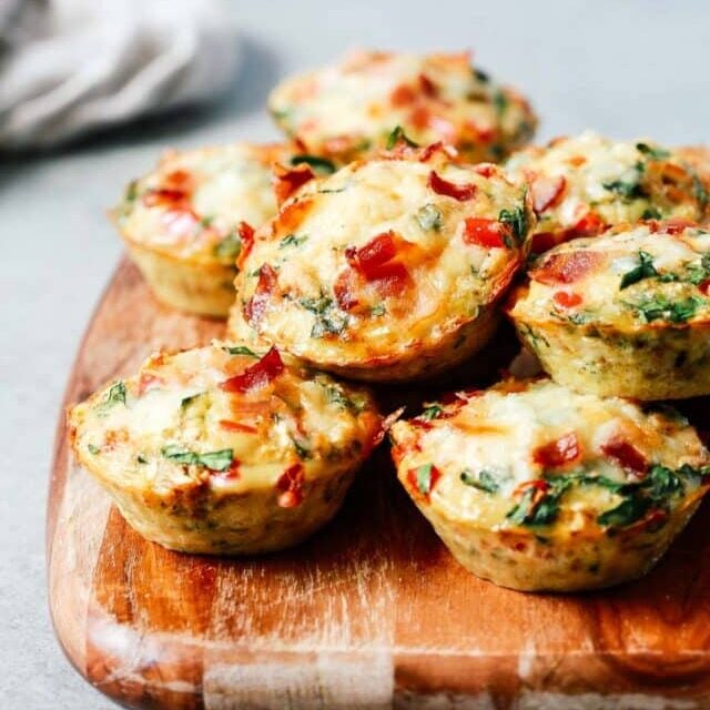 A close up of egg muffins on top of wooden serving board.