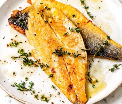 cooked sea bass on a white plate