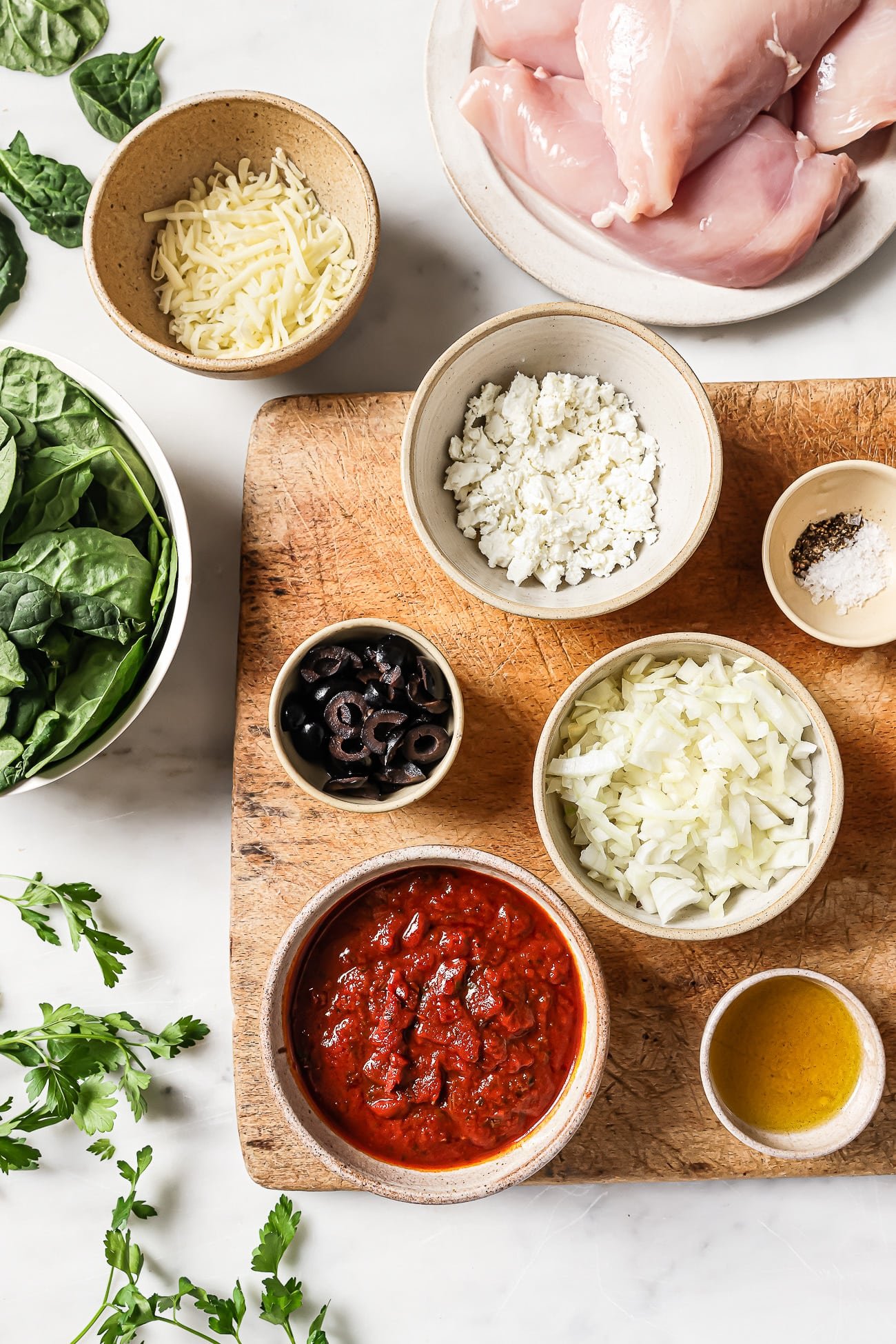 Pre-measured ingredients in small bowls on a wooden cutting board.